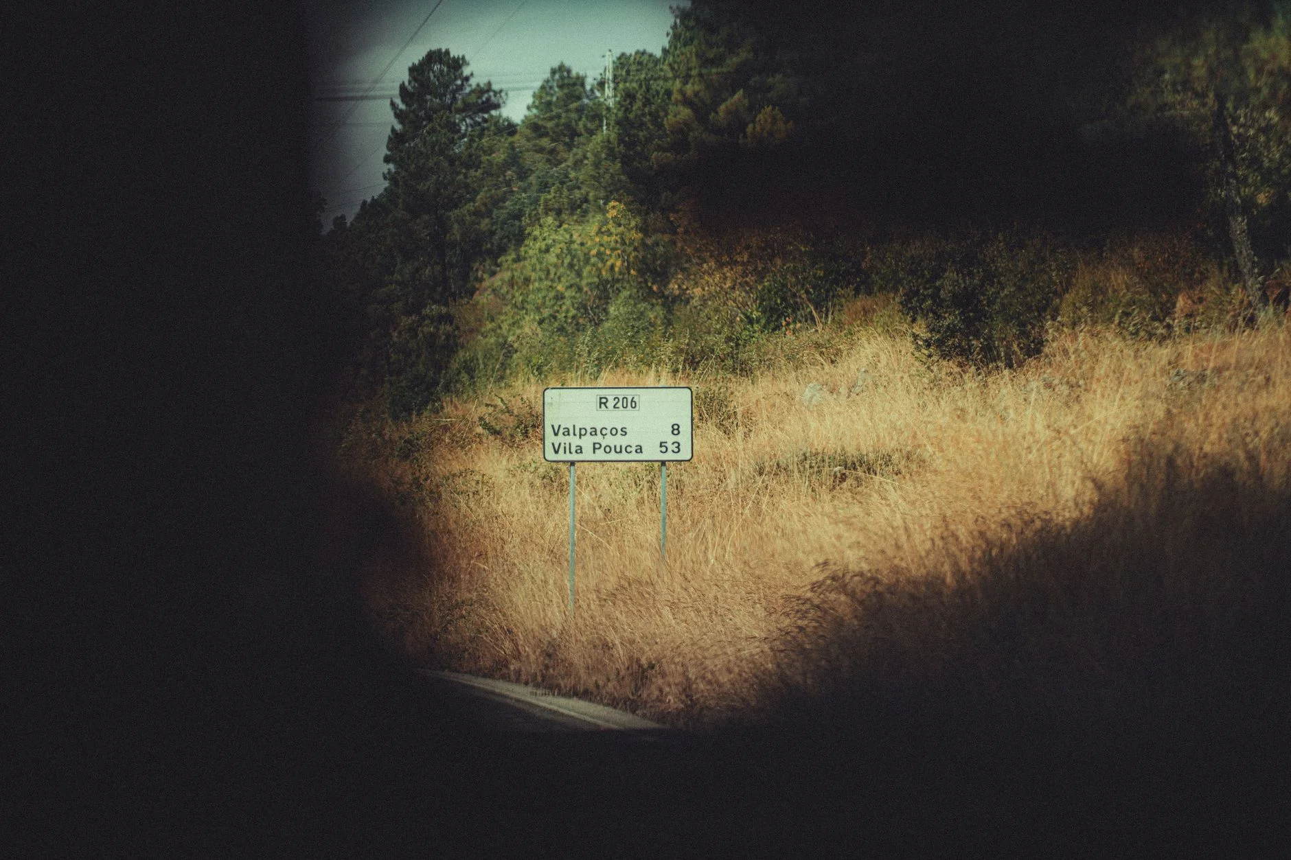 View of rural road R206 with a sign indicating directions to Valpaços and Vila Pouca in Portugal. — Foto: Newman Photographs / Pexels
